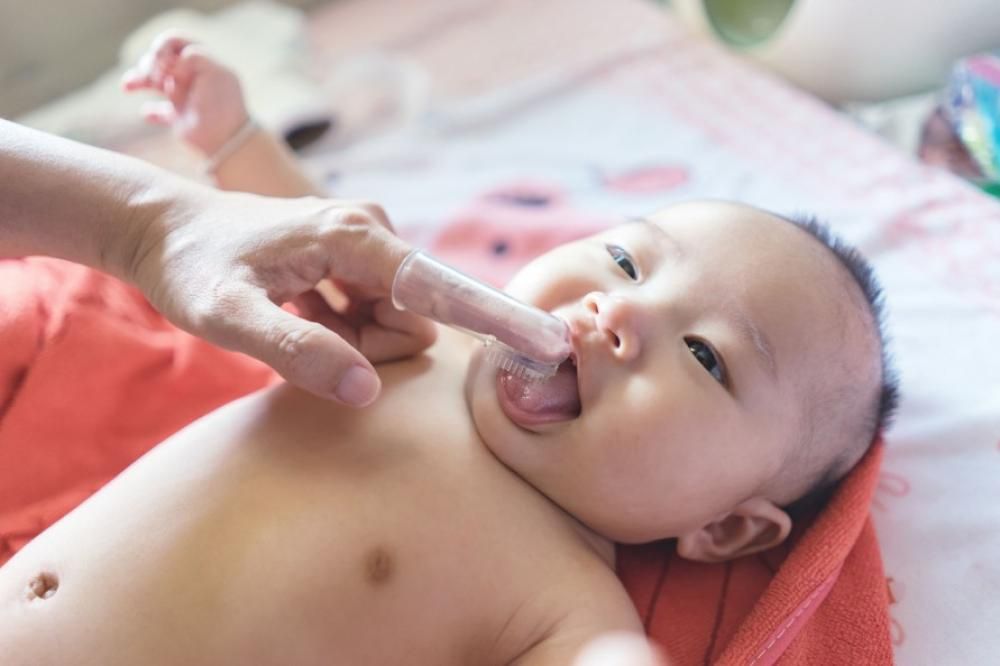 Siga as instruções sobre como limpar a boca deste bebê para manter a saúde bucal do seu filho